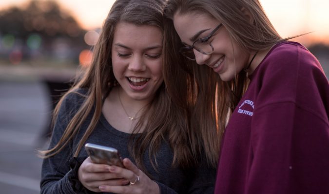 Fotografia di due ragazze che guardano uno smartphone