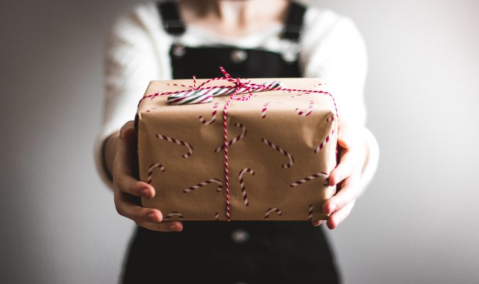 Fotografia di una persona che tiene in mano un pacco regalo