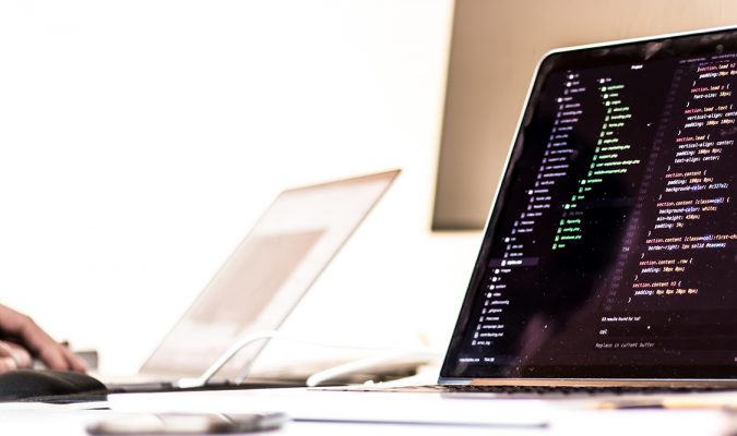 Fotografia di un computer su un tavolo. Sullo schermo codice di programmazione