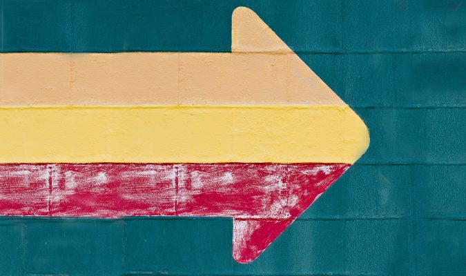 Fotografia di un muro su cui è disegnata una freccia