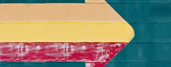 Fotografia di un muro su cui è disegnata una freccia
