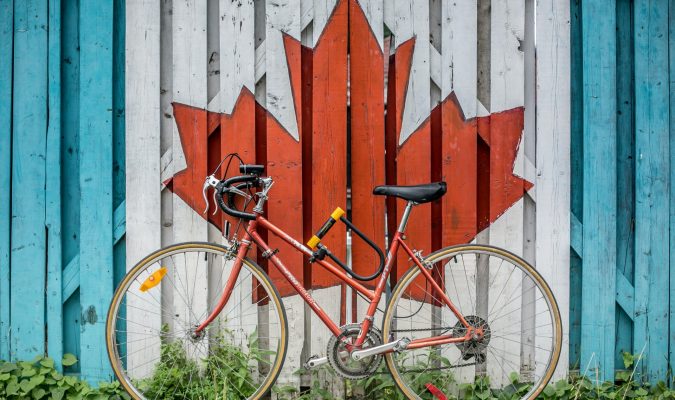 Photo of a byclicle leaning on a mural of a maple leaf