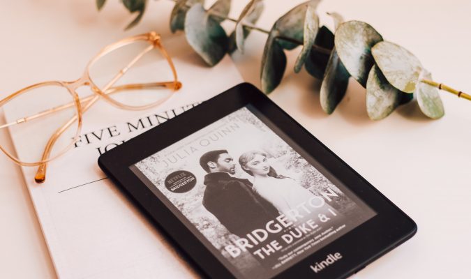 Fotografia di un Kindle e un paio di occhiali su un tavolo