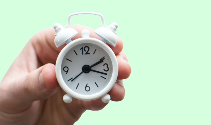 Fotografia di una mano che regge un orologio sveglia