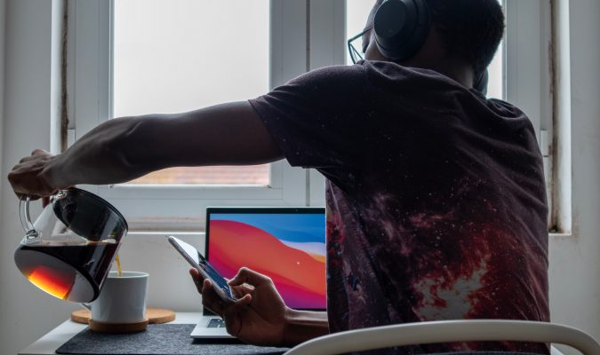 Photograph of a man sitting at a desk with headphones