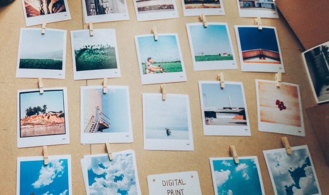 Fotografia di un tavolo su cui sono disposte delle Polaroid con diversi soggetti fotografati