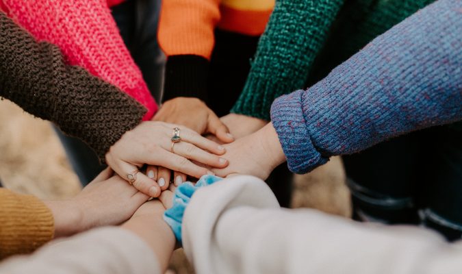 Fotografia di persone in circolo che si danno la mano