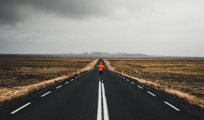 Fotografia di un uomo che corre lungo una strada